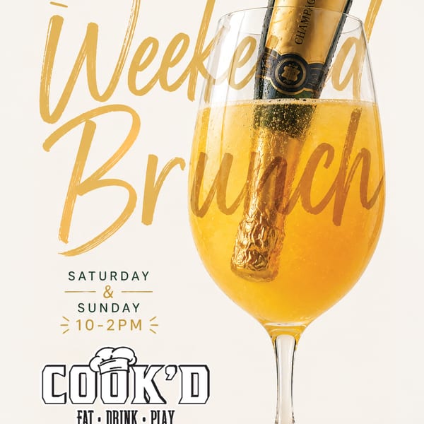 A mimosa glass with a mini champagne bottle inside, advertising "Weekend Brunch" at Cook'd.